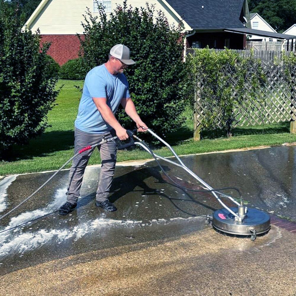 Next Level crew member pressure washing a residential driveway